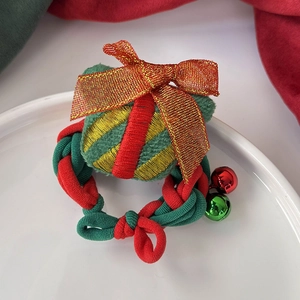 Détail de chouchous de Noël avec des cloches colorées et des nœuds métalliques dorés