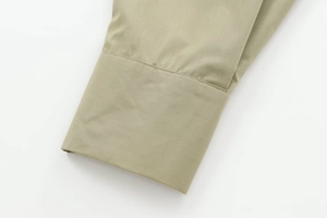 Close-up of olive green poplin shirt cuffs showing fine stitching and fabric texture