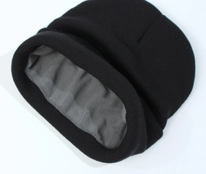 Detail of black knitted beanie showing thick grey fleece lining for winter warmth
