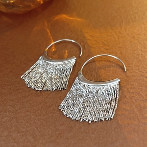Detail of silver tassel drop earrings with metallic semi-circles and long fine chains
