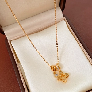 Close-up of gold quatrefoil flower necklace with sparkling zircon in a leather gift box