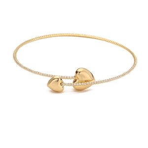 Macro detail of gold-plated bangle featuring heart charms and pave zircon stones