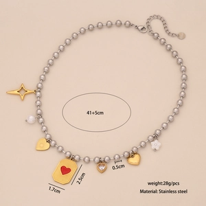 Two-tone stainless steel necklace with pearl, cross, and heart charms on a beige backdrop