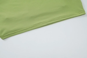 Close-up of double stitching and fine knit texture on a grass green summer garment