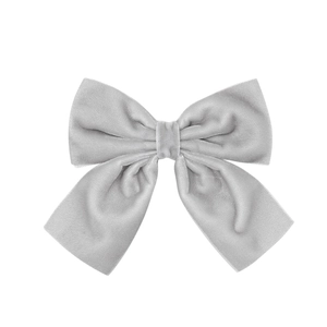 Detailed view of light grey velvet bow clip with soft texture and refined stitching