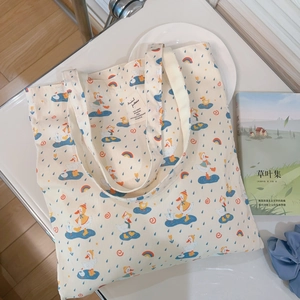 Detail von süßem Entenprint und Markenetikett auf einem beigen Segeltuch-Shopper