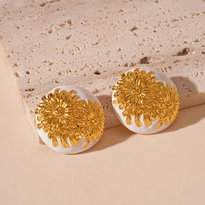 Detailed view of French vintage round daisy earrings with white enamel and gold floral relief
