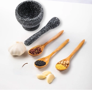 Macro detail of granite pestle and mortar set with three natural long wooden spoons