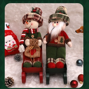 Detail of plush Santa and snowman figures on metal sleighs for Christmas home decor