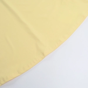 Détail de l'ourlet de la robe jaune clair avec coutures renforcées à double aiguille