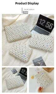 Detail of green floral quilted laptop sleeve with metallic zipper and fabric label