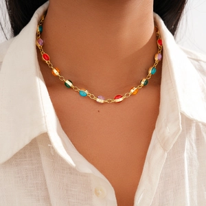 Close-up of vintage golden necklace with colorful oval resin stones on a model