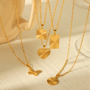 Detailed view of various gold titanium necklaces with starburst textured pendants