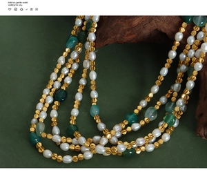 Detailed close-up of layered necklace with freshwater pearls and green agate stones