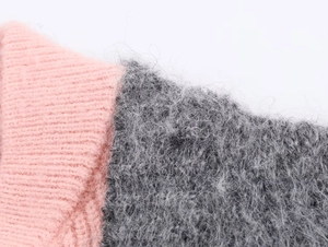 Close-up of pink ribbed knit cuff joined with soft grey mohair faux fur fabric texture