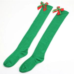 Detail view of green over-knee Christmas socks with decorative red and green bows