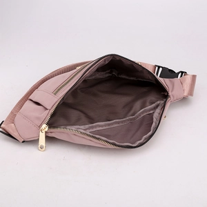 Pink nylon fanny pack for women showing interior brown lining and gold zippers