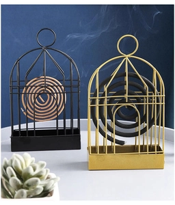 Detail of birdcage-style metal incense holders in gold and black with smoke effect
