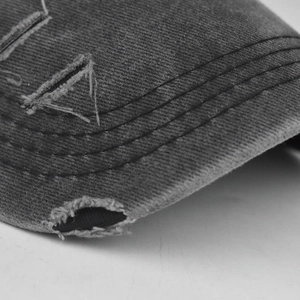 Macro shot of distressed brim edges and vintage sewing on a washed cotton baseball cap