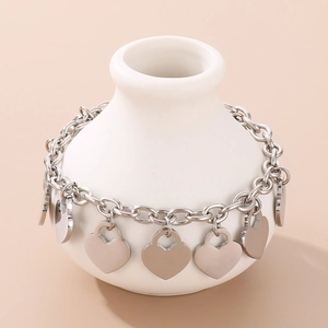 Detailed macro view of silver steel chunky chain bracelet with polished heart charms