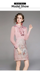 Close-up of ruffled lapel collar and pink floral embroidery on an elegant dress