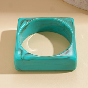 Macro shot of turquoise marble resin square bangle with a smooth polished finish