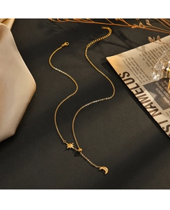 Detailed shot of 14K gold plated star and moon pendant necklace with white zircon inlays