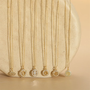 Golden cross and mystic charms necklace set with zircon accents on stone podium
