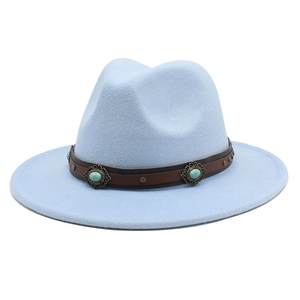 Détail du chapeau en laine bleu clair avec bande en cuir marron et pierre turquoise
