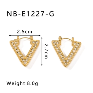 Macro shot of V-shaped gold-plated stainless steel earrings with sparkling crystals