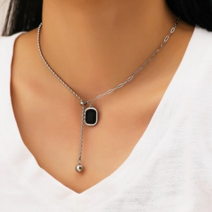 Silver-toned chain necklace featuring a rectangular black pendant and mixed bead links