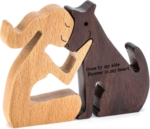 Detail of wooden sculpture showing a woman hugging a dog with heart engraving