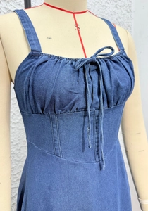 Detail of blue denim sundress showing thin straps and drawstring bow on the bust