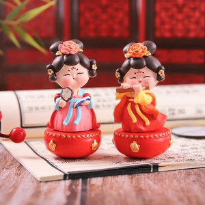 Detail of two traditional Chinese style doll figurines placed on vintage open book pages