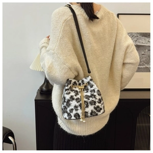 Detail of plush leopard print bucket bag with gold chain tassels and soft furry texture