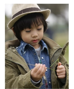 Detail of beige straw hat with military green parka and star denim shirt for kids