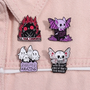 Detail of four creative Halloween enamel pins styled on a pink denim jacket pocket