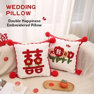 Detail of red and white wedding pillow set with traditional Xi embroidery and pom-poms