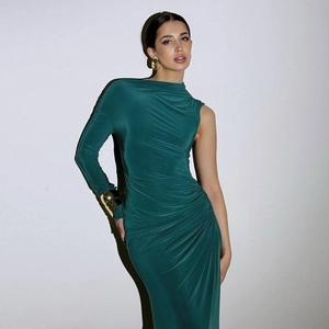 Detail of emerald green one-shoulder dress with elegant side ruching and silky texture