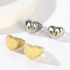Set of gold and silver heart rings with polished finish and radial striped edges