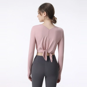 Pink long sleeve yoga top with V-back knot design and grey high waist leggings