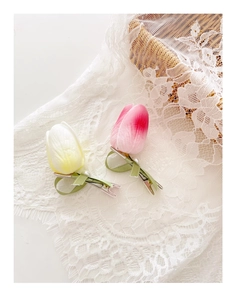 Detail of tulip hair clips with silk ribbons and pearls on a lace background