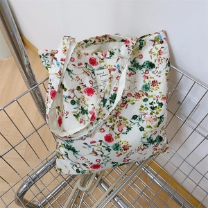 Dettaglio della borsa tote in tela floreale nel carrello con stampa vintage e tracolla