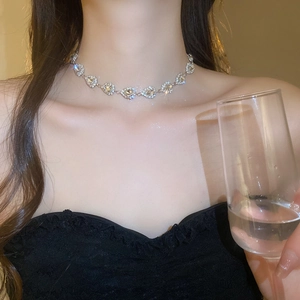 Close-up of sparkling waterdrop rhinestone necklace on model wearing black dress