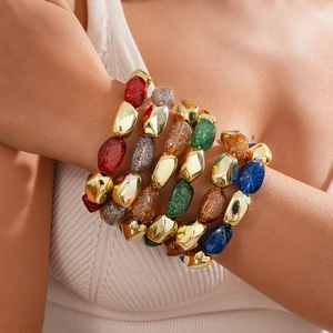 Macro shot of colorful resin sequins and golden metallic beads on bohemian bracelet set