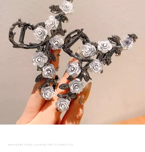Detail of grey alloy hair claw clips with white 3D roses and sparkling dark rhinestones