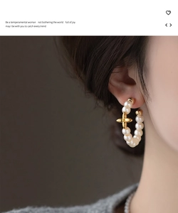 Close-up of pearl hoop earring with gold floral accent on a female model