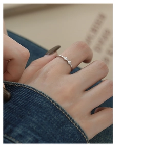 Detailed view of s925 silver bow ring with micro-set zircon on model finger