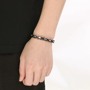 Close-up of men's two-tone black and silver Byzantine chain bracelet on wrist