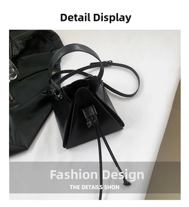 Detail view of the black leather geometric triangle handbag with drawstring closure